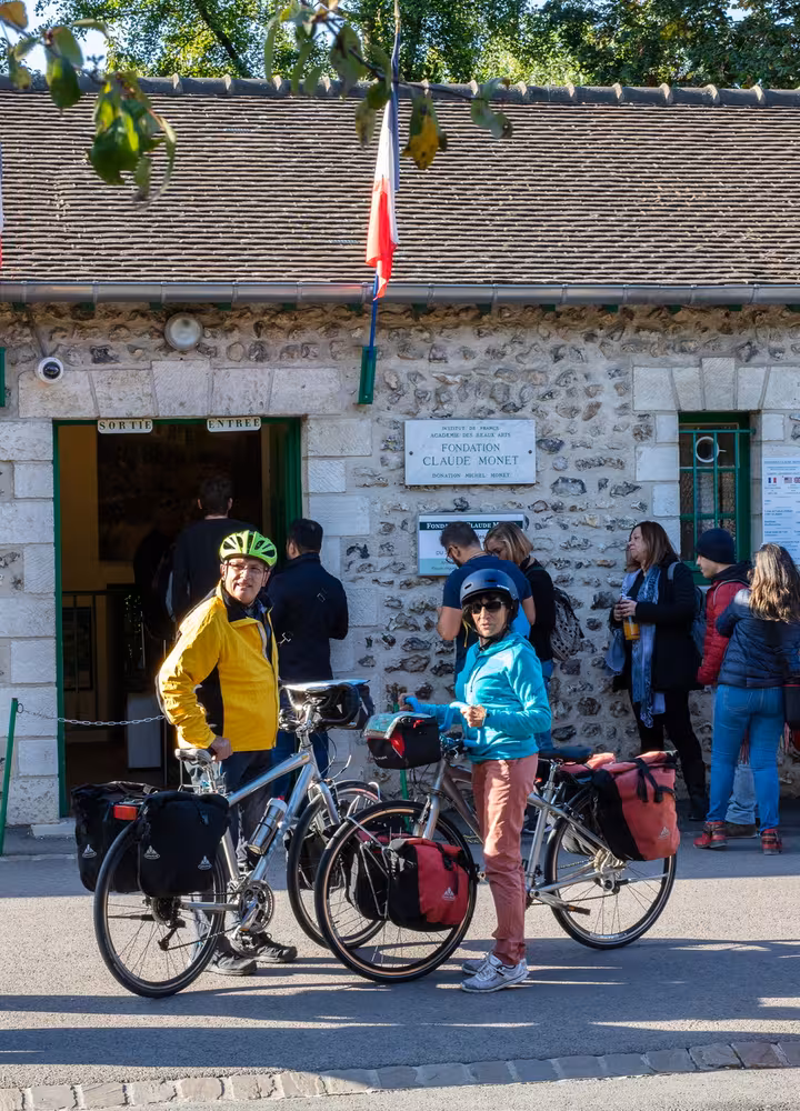 Voyageurs à vélo devant l'entrée de la maison de Claude Monet à Giverny
