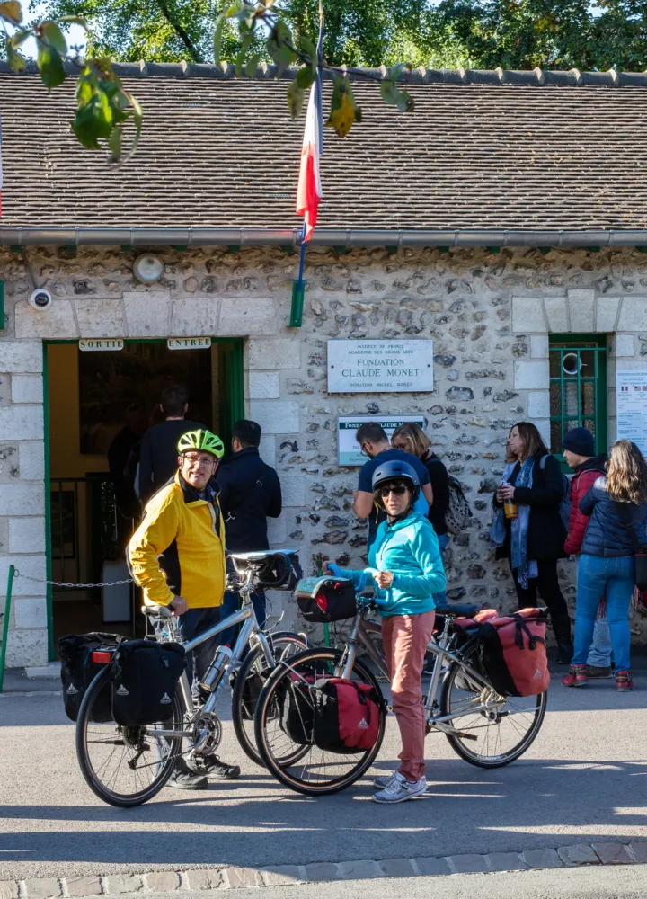 Voyageurs à vélo devant l'entrée de la maison de Claude Monet à Giverny