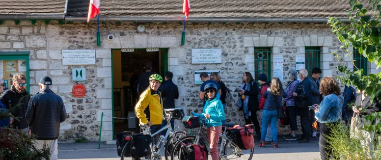 Voyageurs à vélo devant l'entrée de la maison de Claude Monet à Giverny