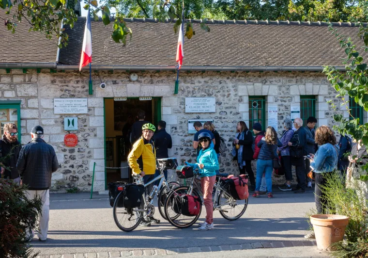 Voyageurs à vélo devant l'entrée de la maison de Claude Monet à Giverny